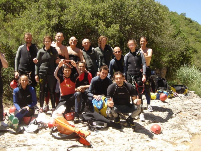 grupo de personas con trajes de neopreno con arboles de fondo